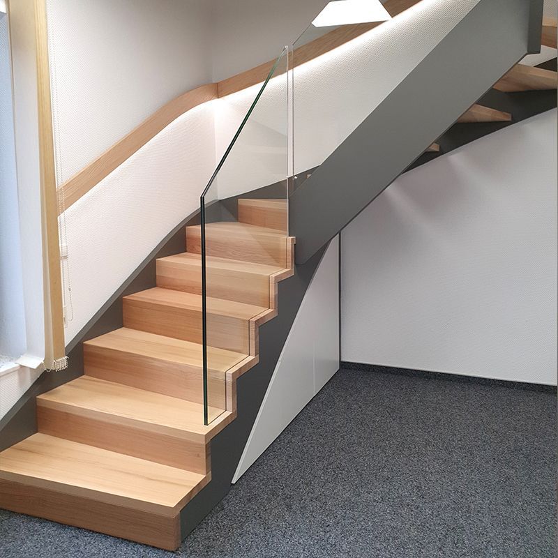 Eine Treppe mit Holzstufen und einem Glasgeländer