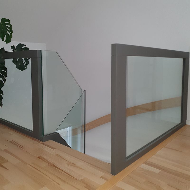 Eine Treppe mit Glasgeländer und einer Pflanze im Hintergrund