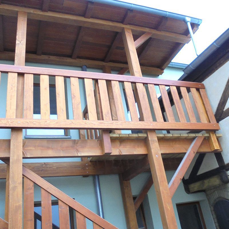 Ein Holzbalkon mit Treppe, die hinaufführt