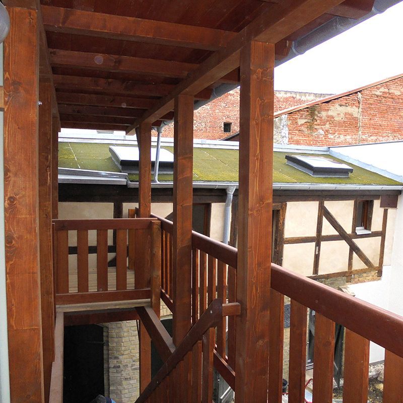 Eine Holztreppe, die zu einem Gebäude mit Gründach führt