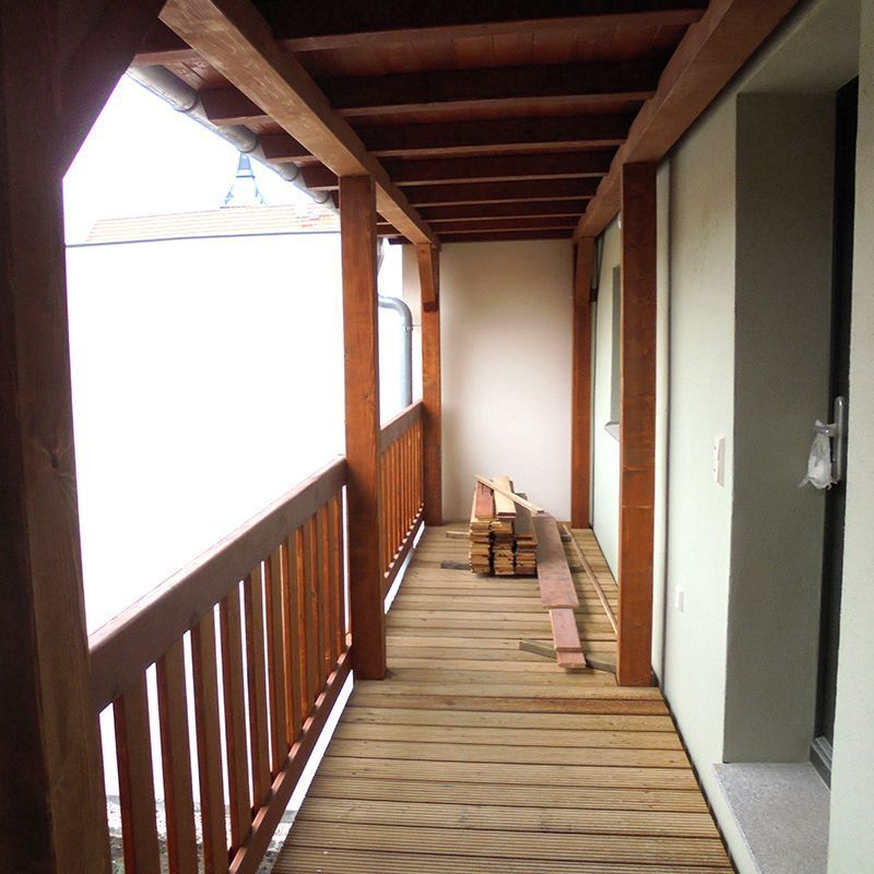 Ein langer Holzflur mit einem Holzgeländer