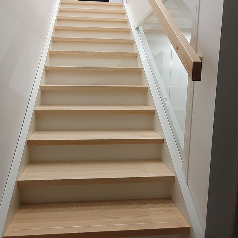 Eine Treppe mit Holzstufen und einem Glasgeländer