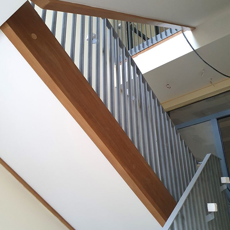 Blick nach oben auf eine Treppe mit einem Metallgeländer