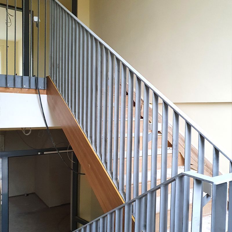 Eine Treppe mit Metallgeländer und Holzstufen