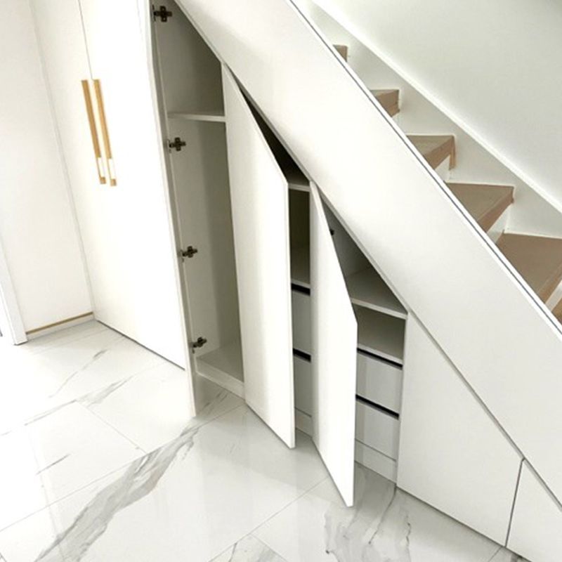 Ein weißer Schrank unter einer Treppe mit offenen Türen