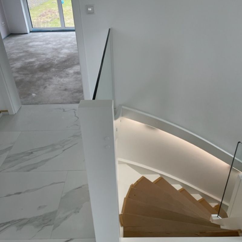 Eine Wendeltreppe mit Glasgeländer und Marmorboden