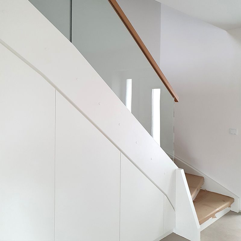 Eine weiße Treppe mit Holzstufen und einem Glasgeländer