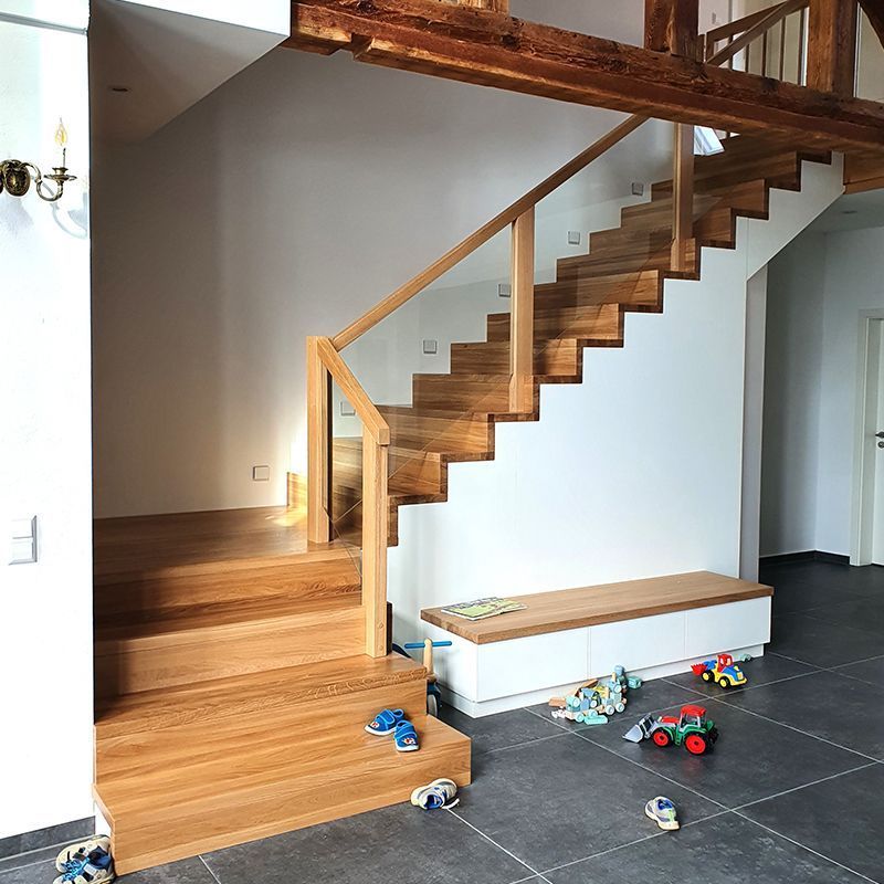 Eine Holztreppe mit einem Glasgeländer in einem Haus