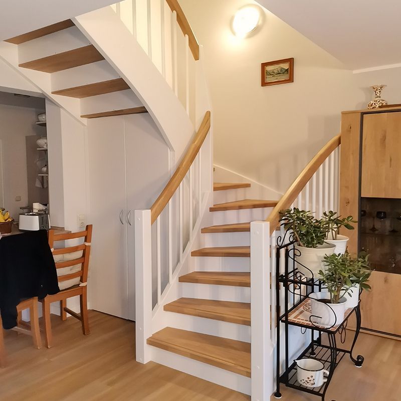 Eine Treppe mit Holzstufen und einem weißen Geländer