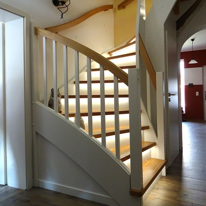 Eine Treppe mit Holzstufen und einem weißen Geländer