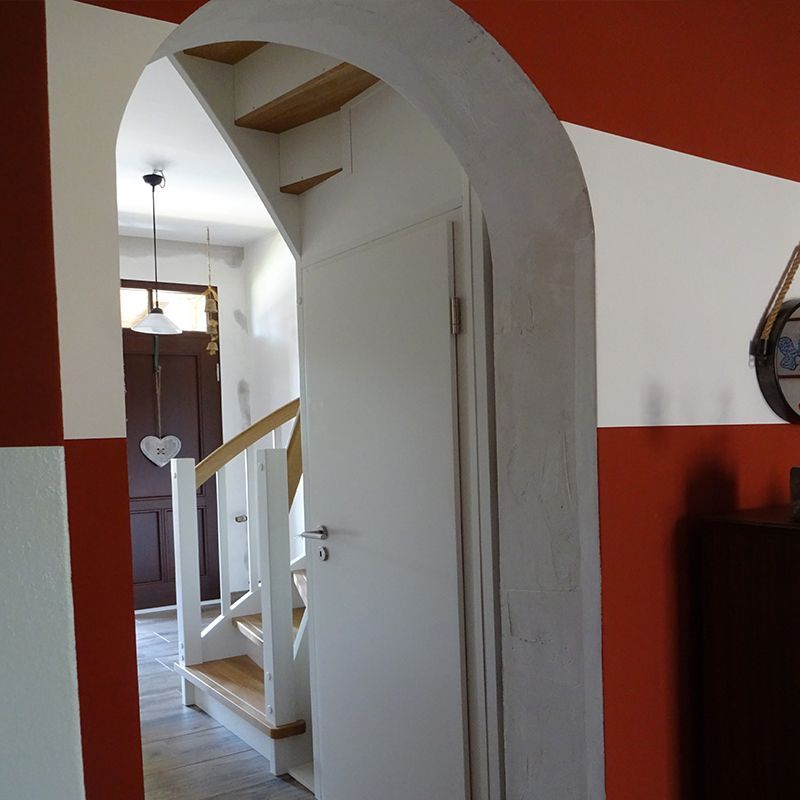 Eine Tür, die zu einer Treppe mit einer rot-weiß gestreiften Wand führt