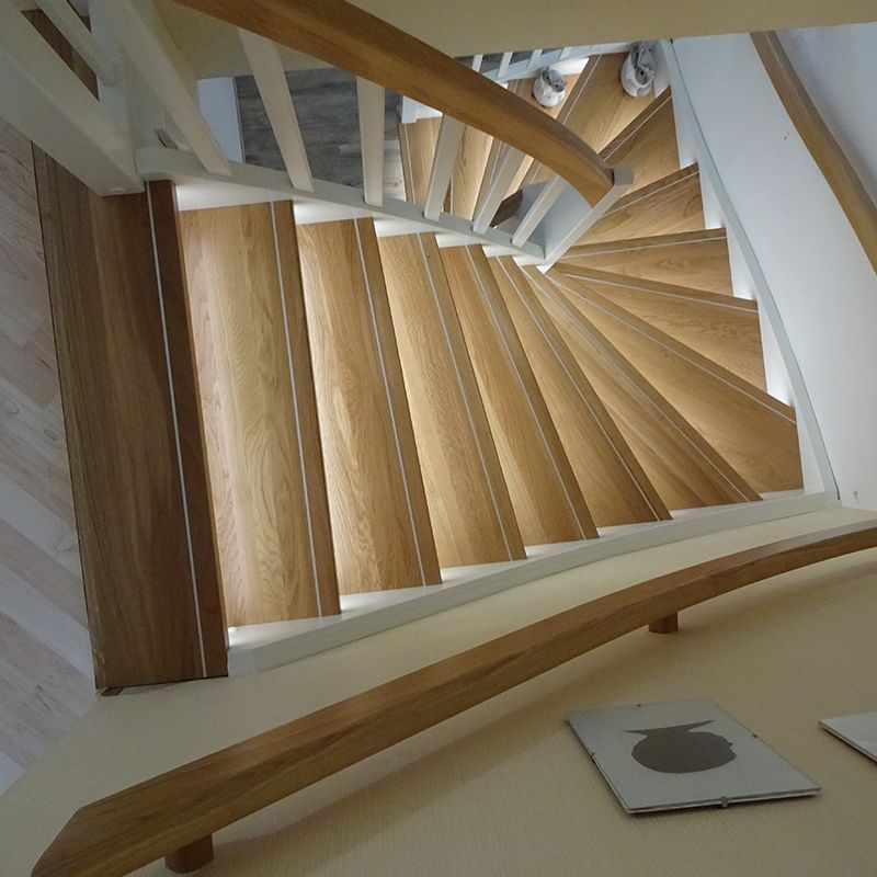 Eine Wendeltreppe mit Holzstufen und einem weißen Geländer