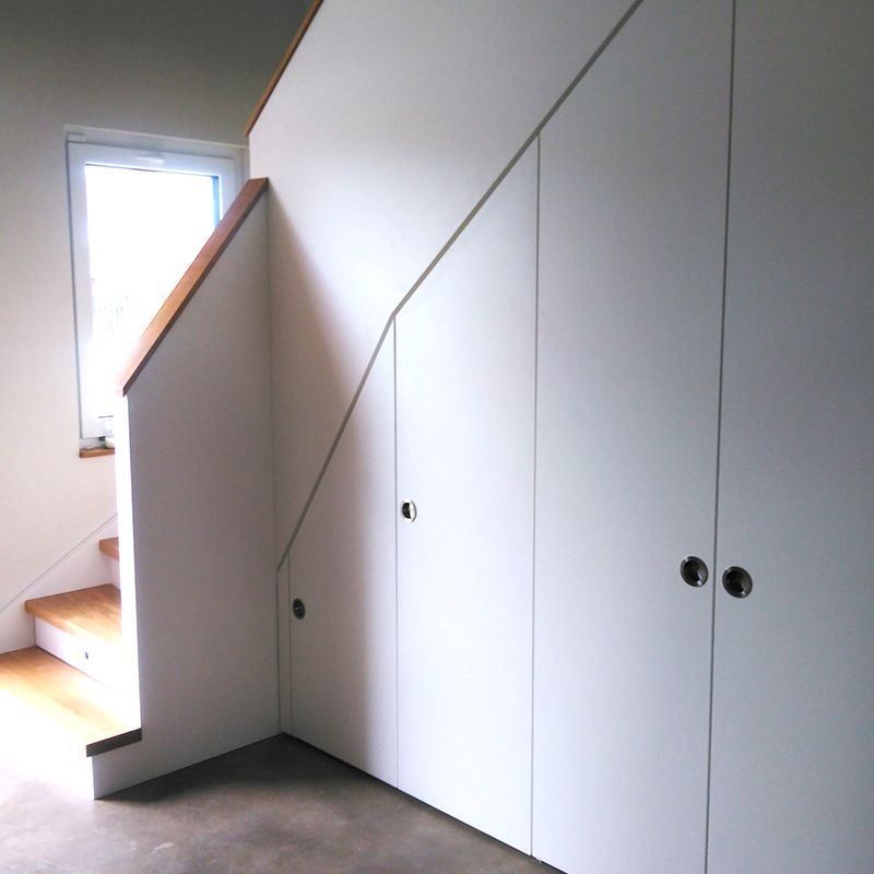 Eine Treppe mit weißen Schränken darunter