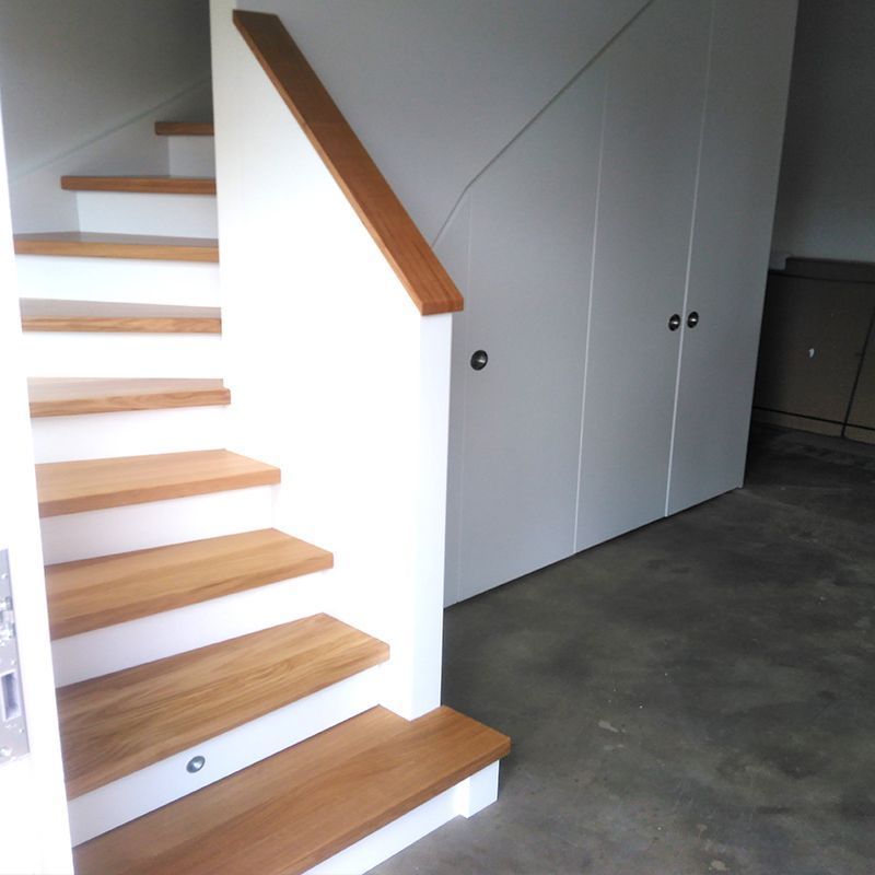 Eine Treppe mit Holzstufen und einem weißen Geländer