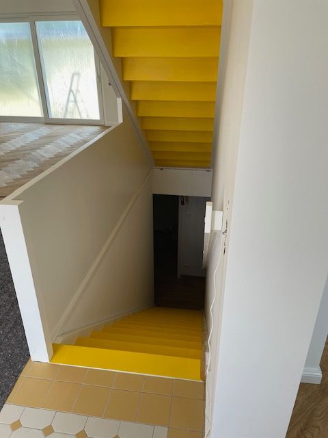 Eine gelbe Treppe führt in den zweiten Stock eines Hauses.
