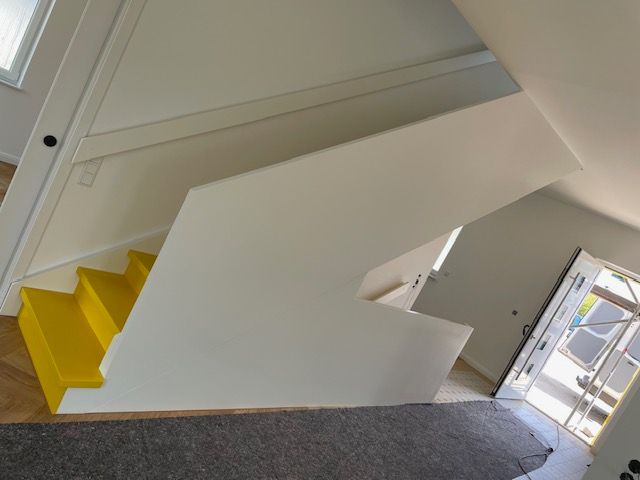 Eine Treppe mit gelben Stufen und einem weißen Geländer