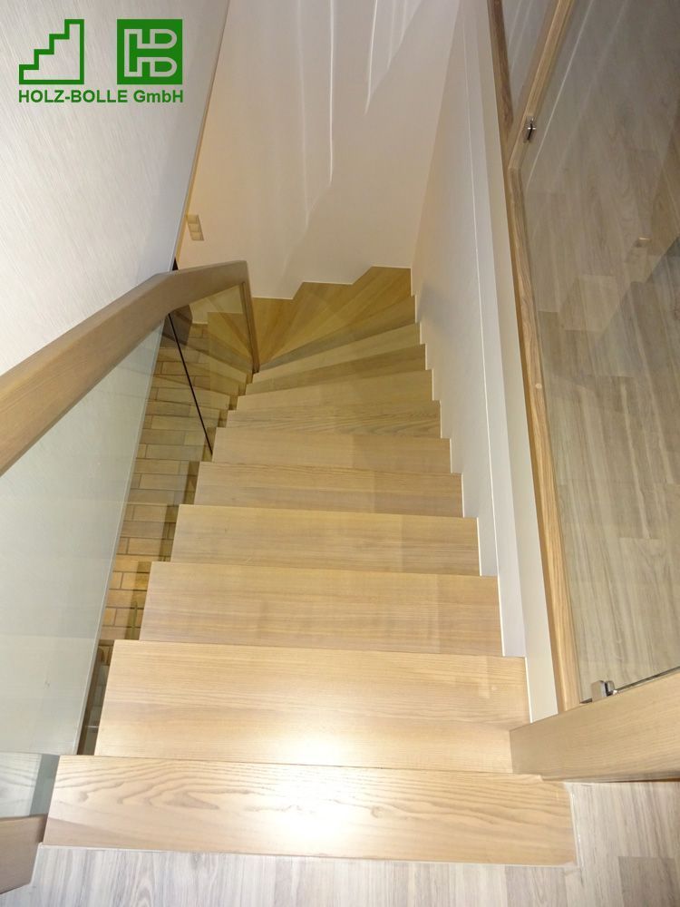 Eine Holztreppe mit Glasgeländer und hb-Logo