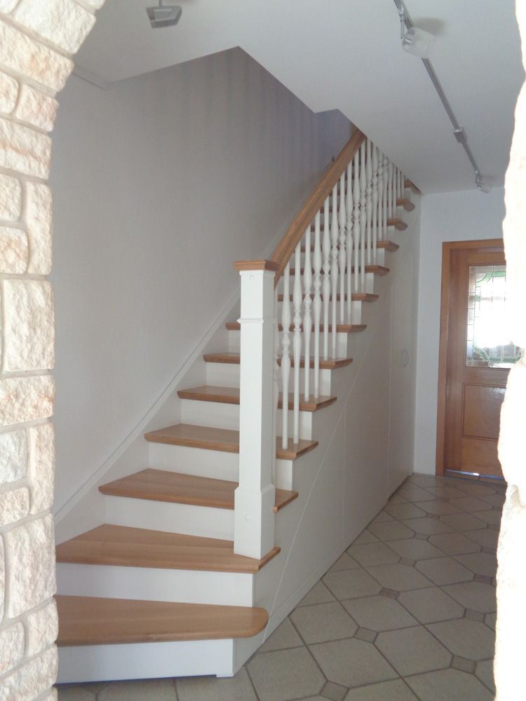 Eine Treppe mit Holzstufen und einem weißen Geländer