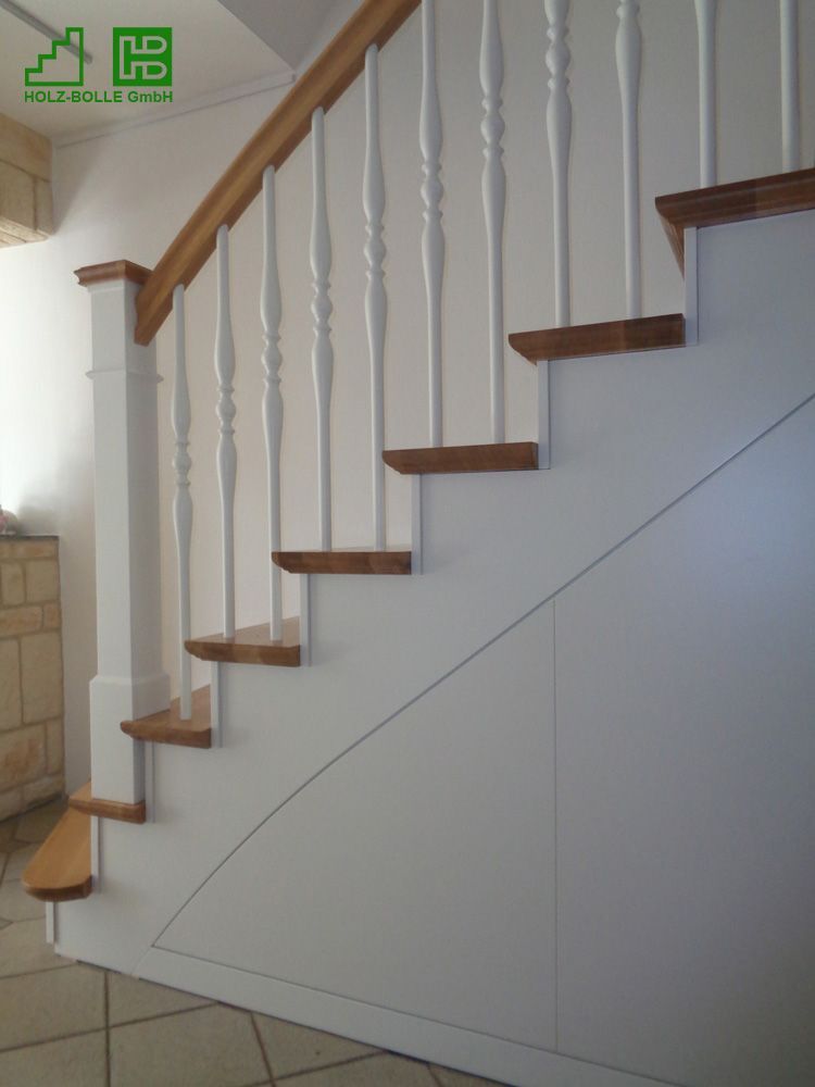 Eine Treppe mit weißem Geländer und Holzstufen