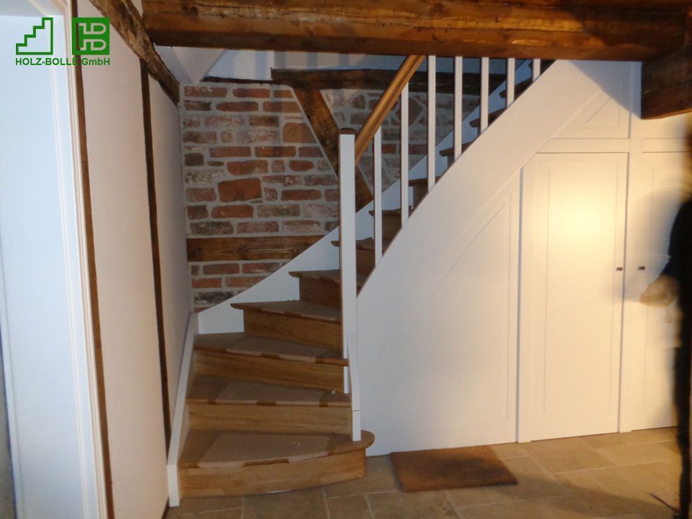Eine Treppe mit einer Ziegelwand und einem weißen Geländer