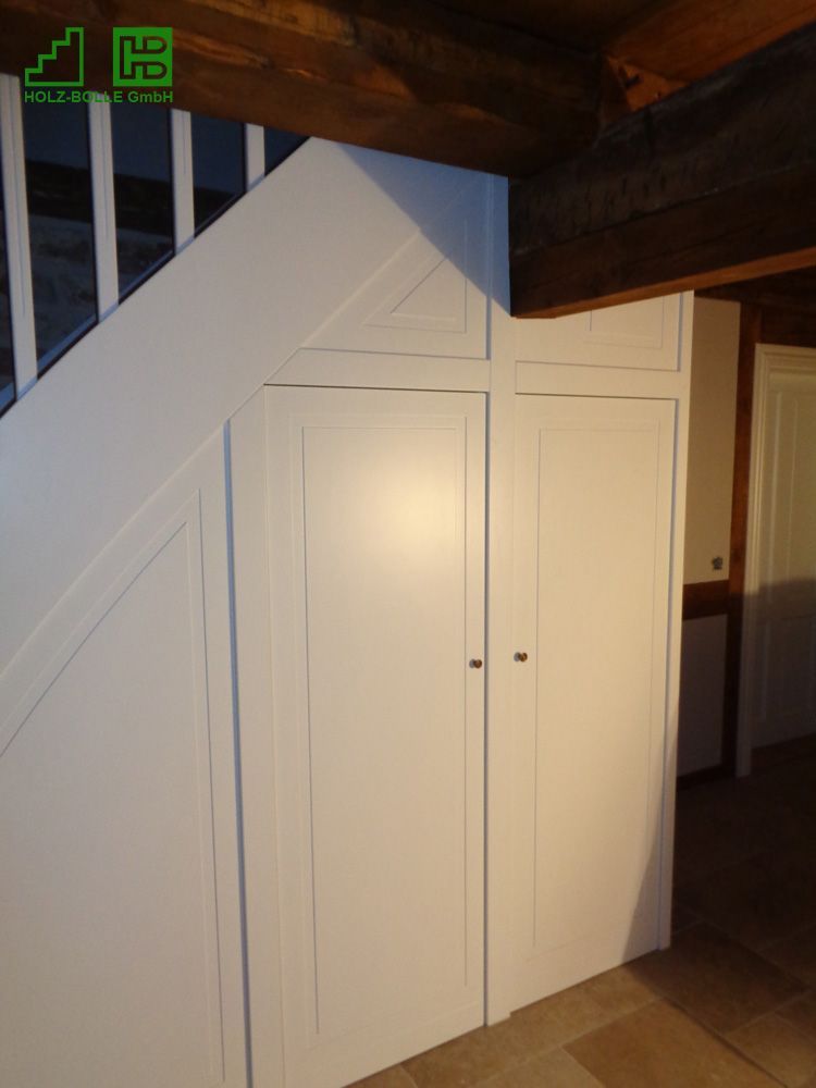 Eine Treppe mit weißen Schränken darunter