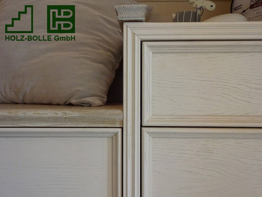 Ein Kissen liegt auf einem Regal neben einer Schublade mit der Aufschrift „Holz-Bolle GmbH“