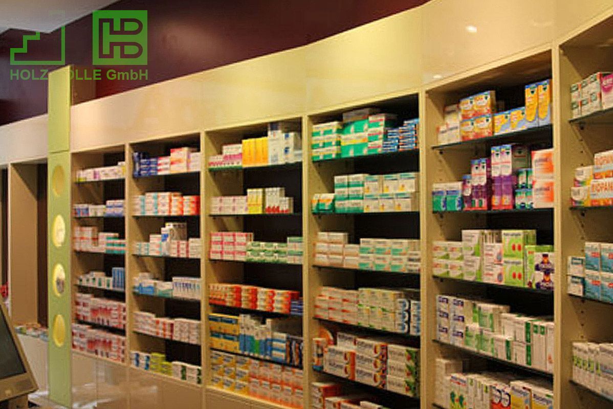 Regale in einer Apotheke mit dem Buchstaben H an der Wand