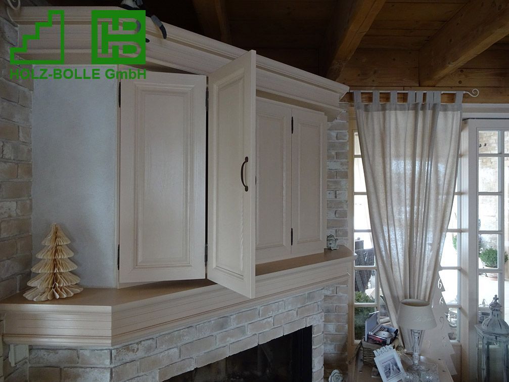 Ein Wohnzimmer mit Kamin und weißen Schränken