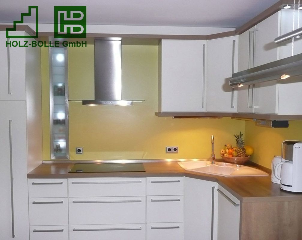 Eine Küche mit weißen Schränken und einer Dunstabzugshaube aus Edelstahl