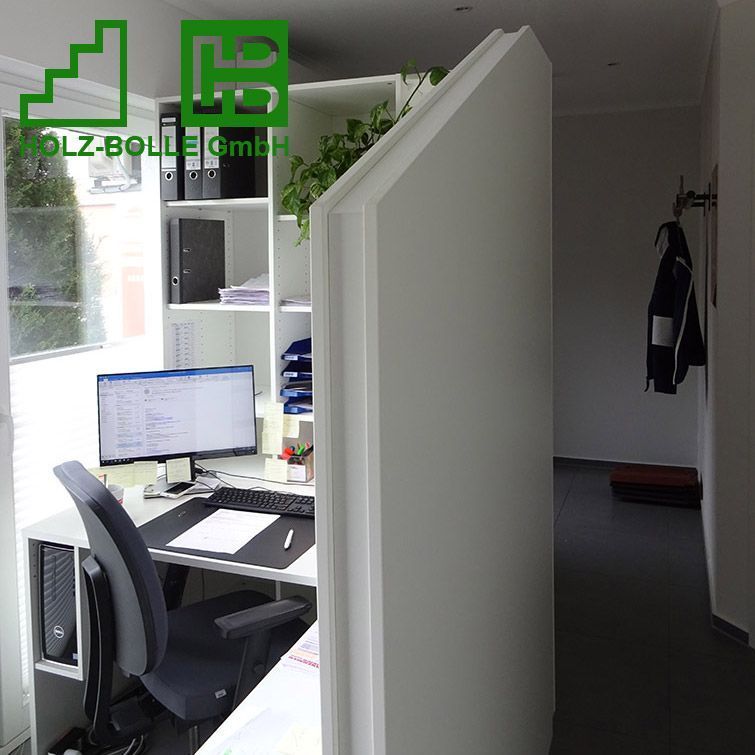 Ein Computer steht auf einem Schreibtisch in einem Raum mit einem Schild mit der Aufschrift „Holz-Bölle GmbH“