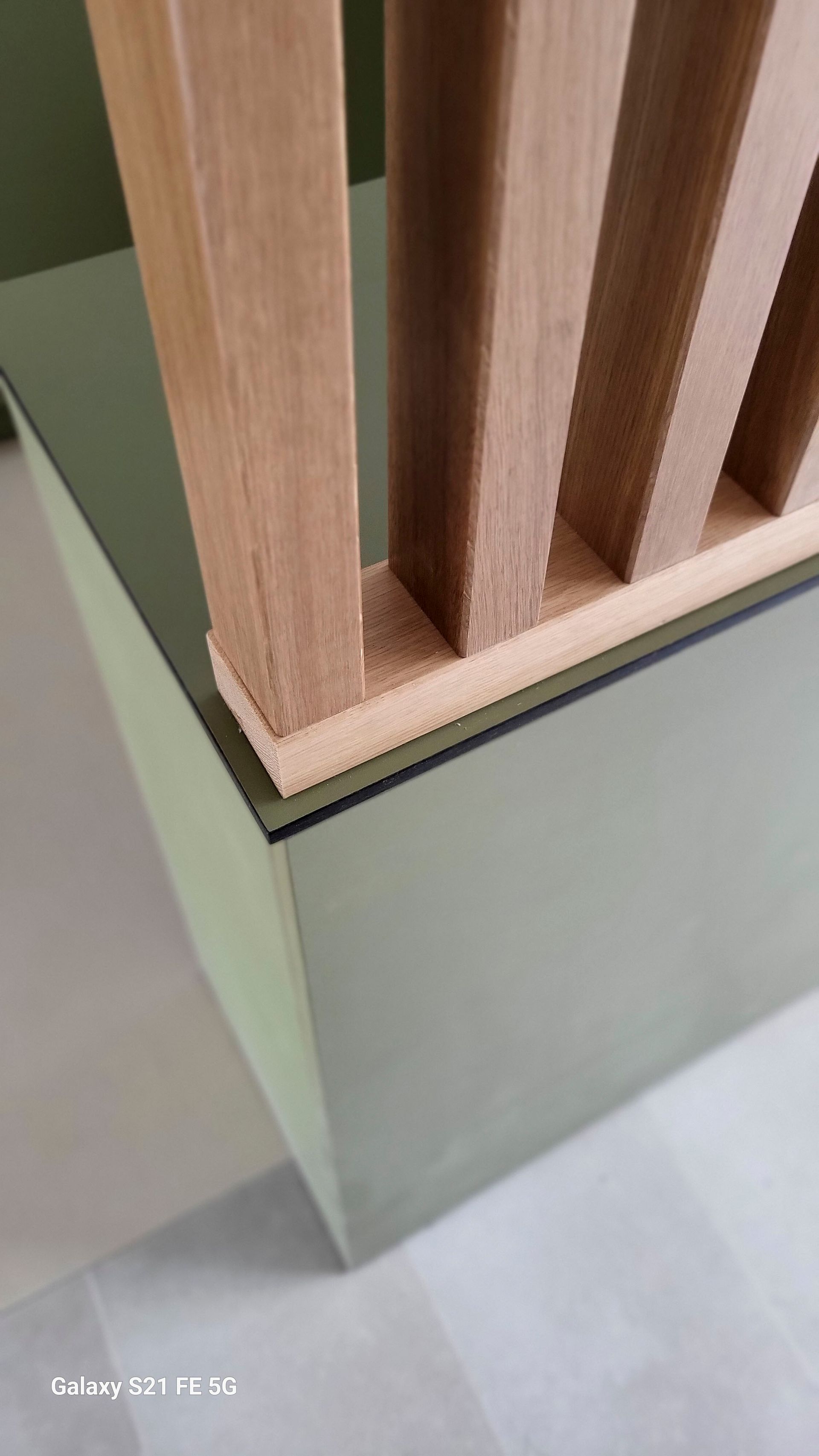 Auf einem Glastisch steht ein Holzzaun.