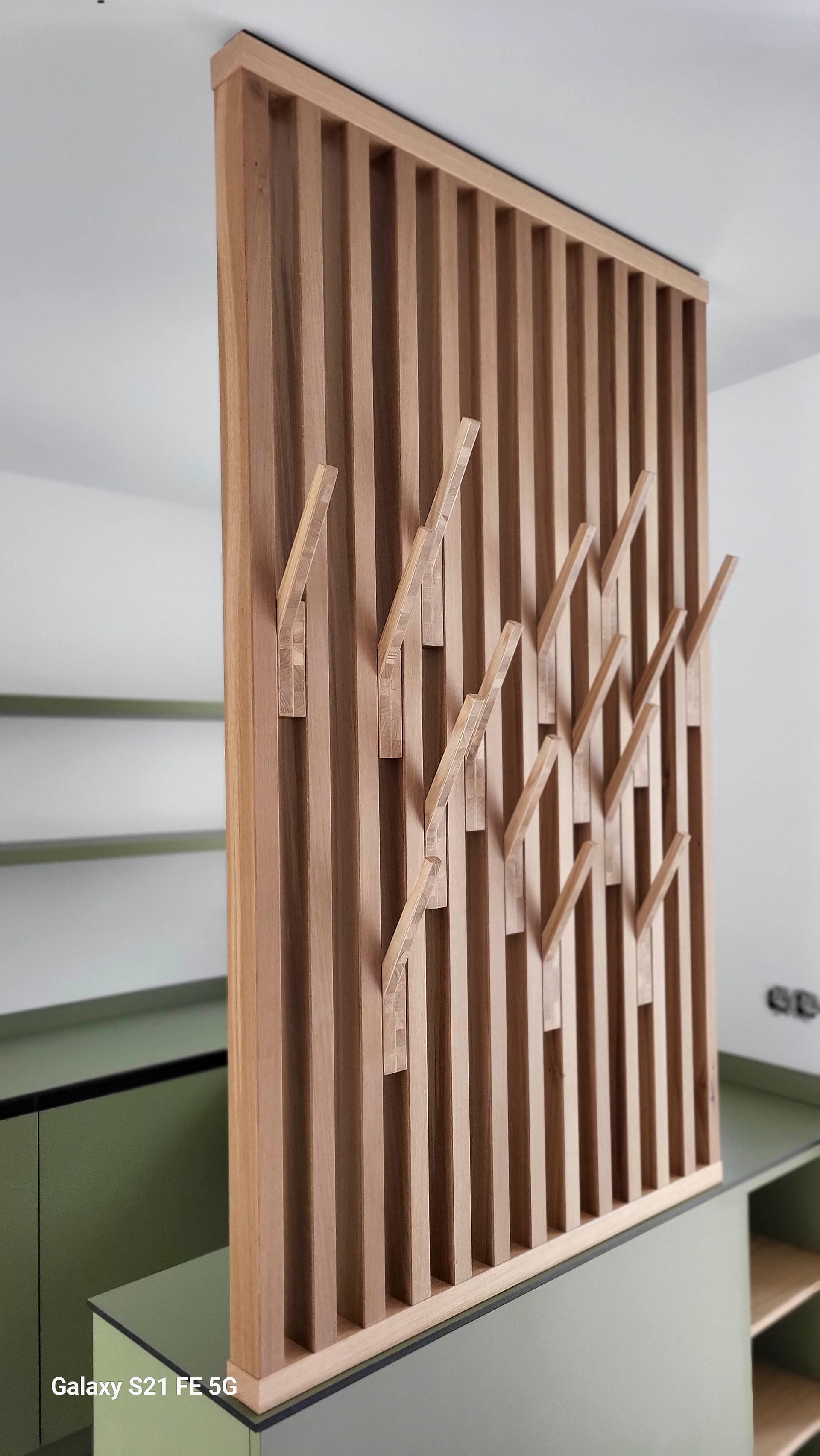 Eine Holzwand mit Haken in einem Raum.