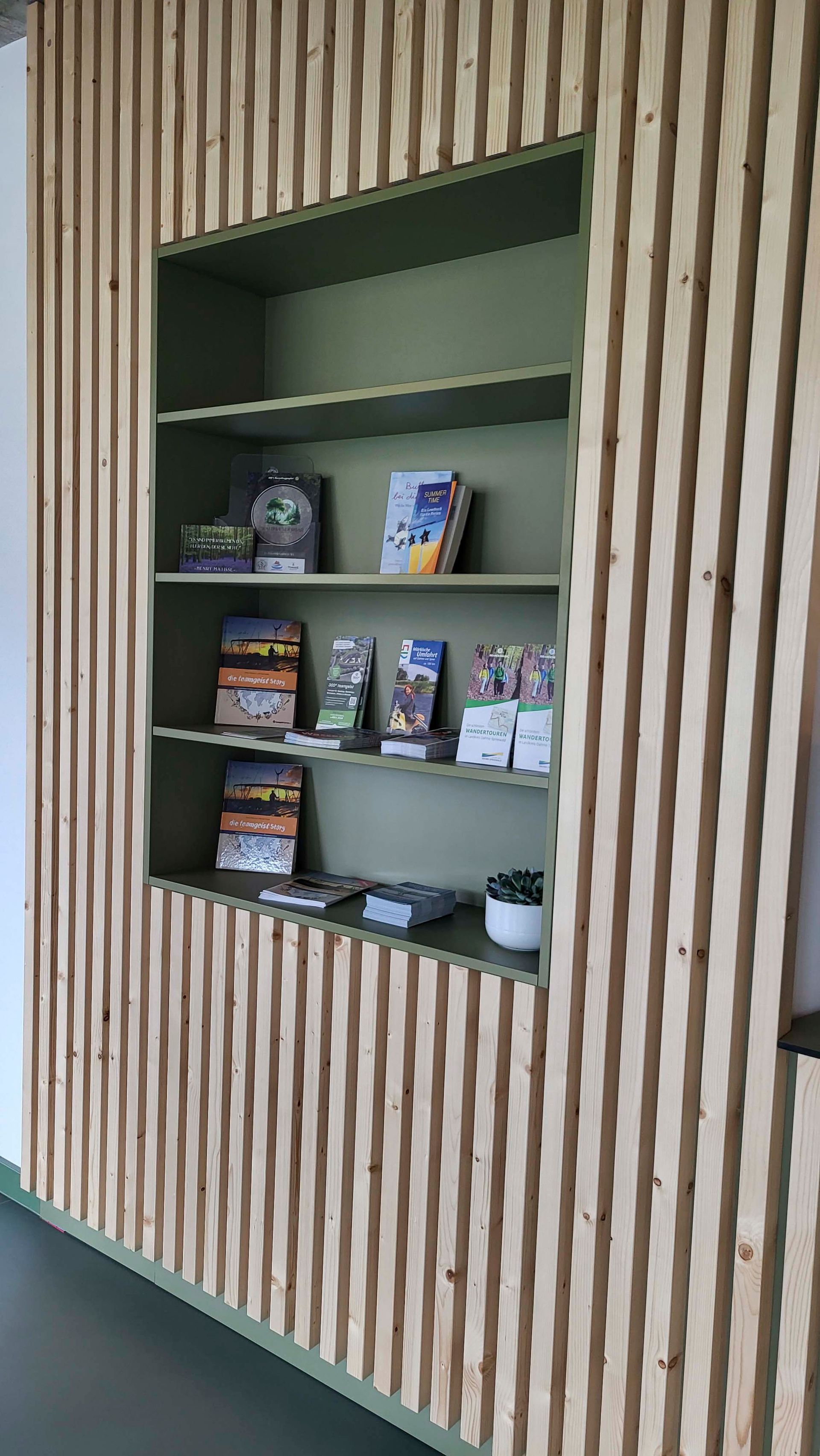 Eine Holzwand mit Regalen voller Bücher und Zeitschriften.