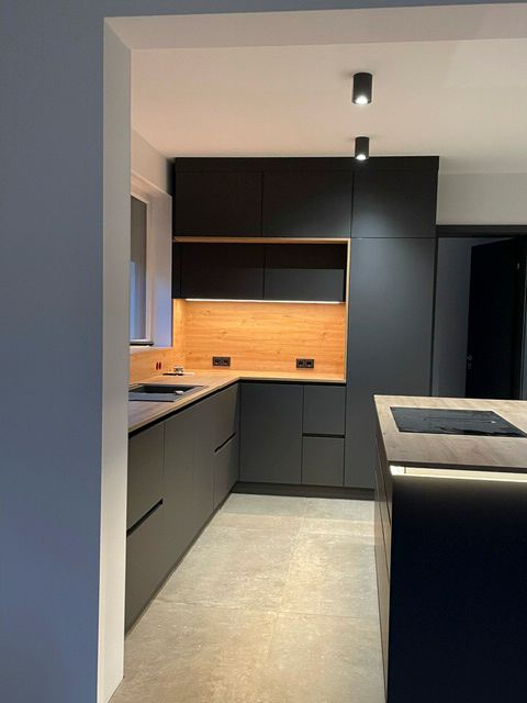 Eine Küche mit schwarzen Schränken und Holzarbeitsplatten