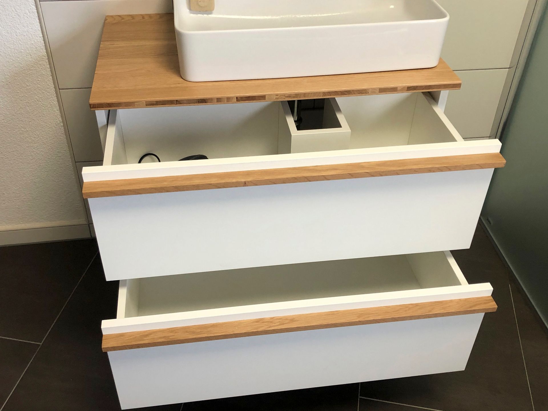 Ein Badezimmerschrank mit Waschbecken und offenen Schubladen