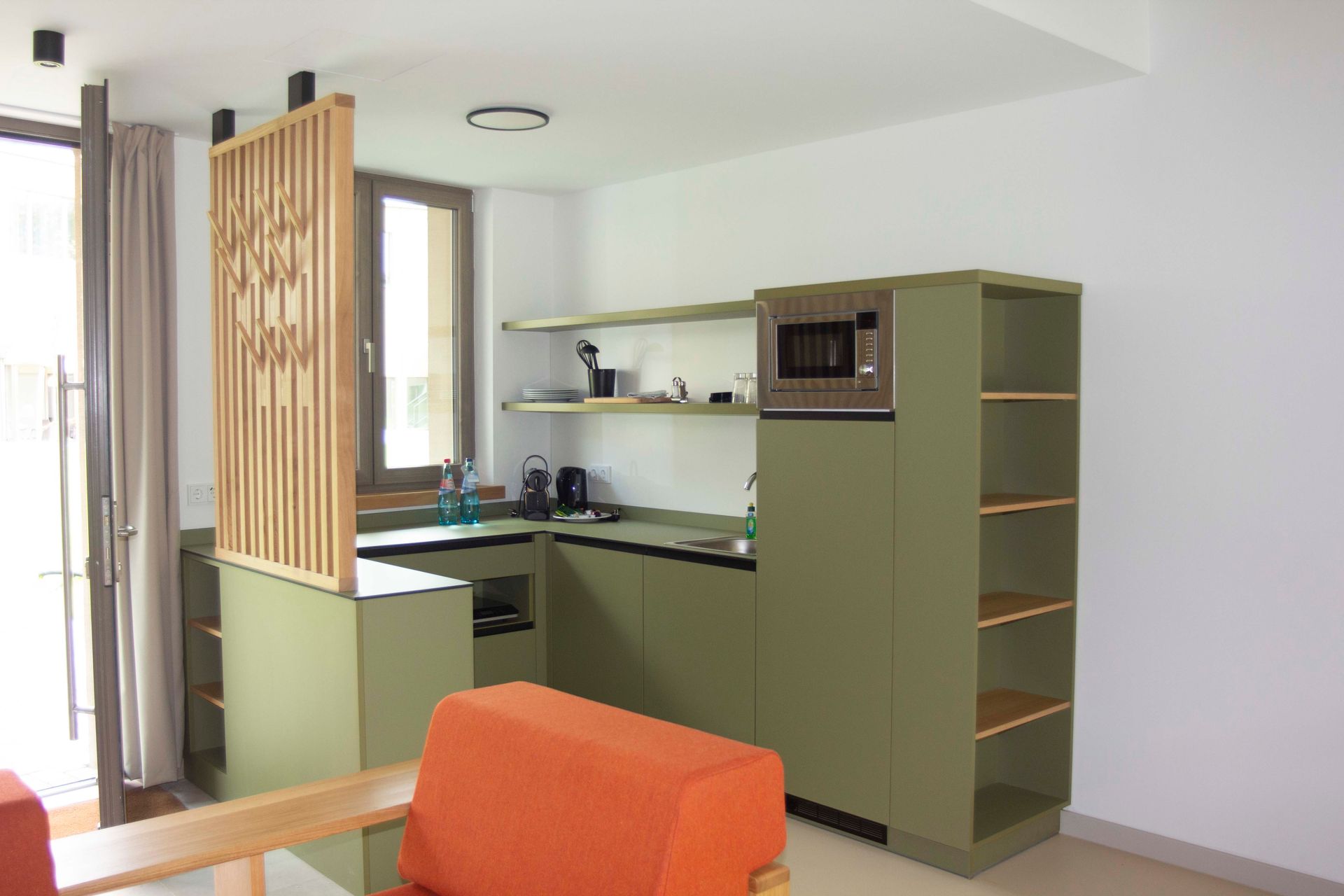Eine Küche mit grünen Schränken und einer Mikrowelle