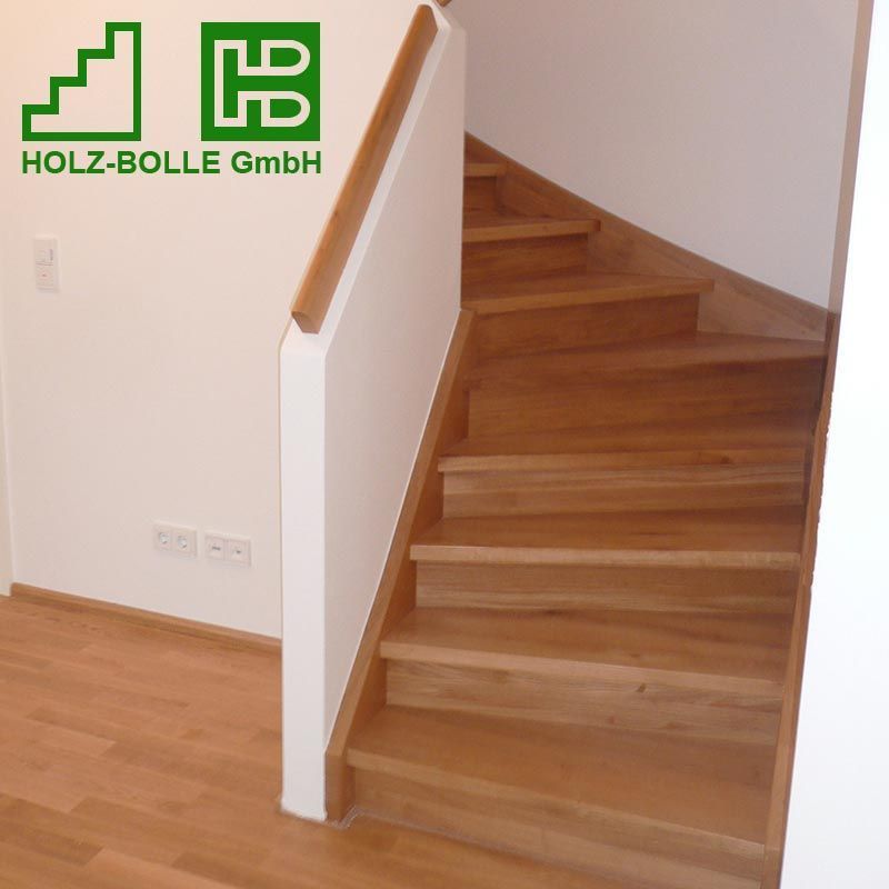 Eine Holztreppe mit einem Holz-Bölle GmbH Logo an der Wand