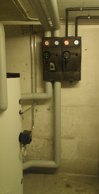Wandmontierter elektrischer Schaltschrank mit Rohrleitungen in einem Keller oder Hauswirtschaftsraum