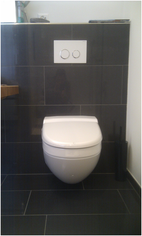 Modernes, schwarz gefliestes WC mit weisser, wandhängender Toilette und Zweimengenspülung