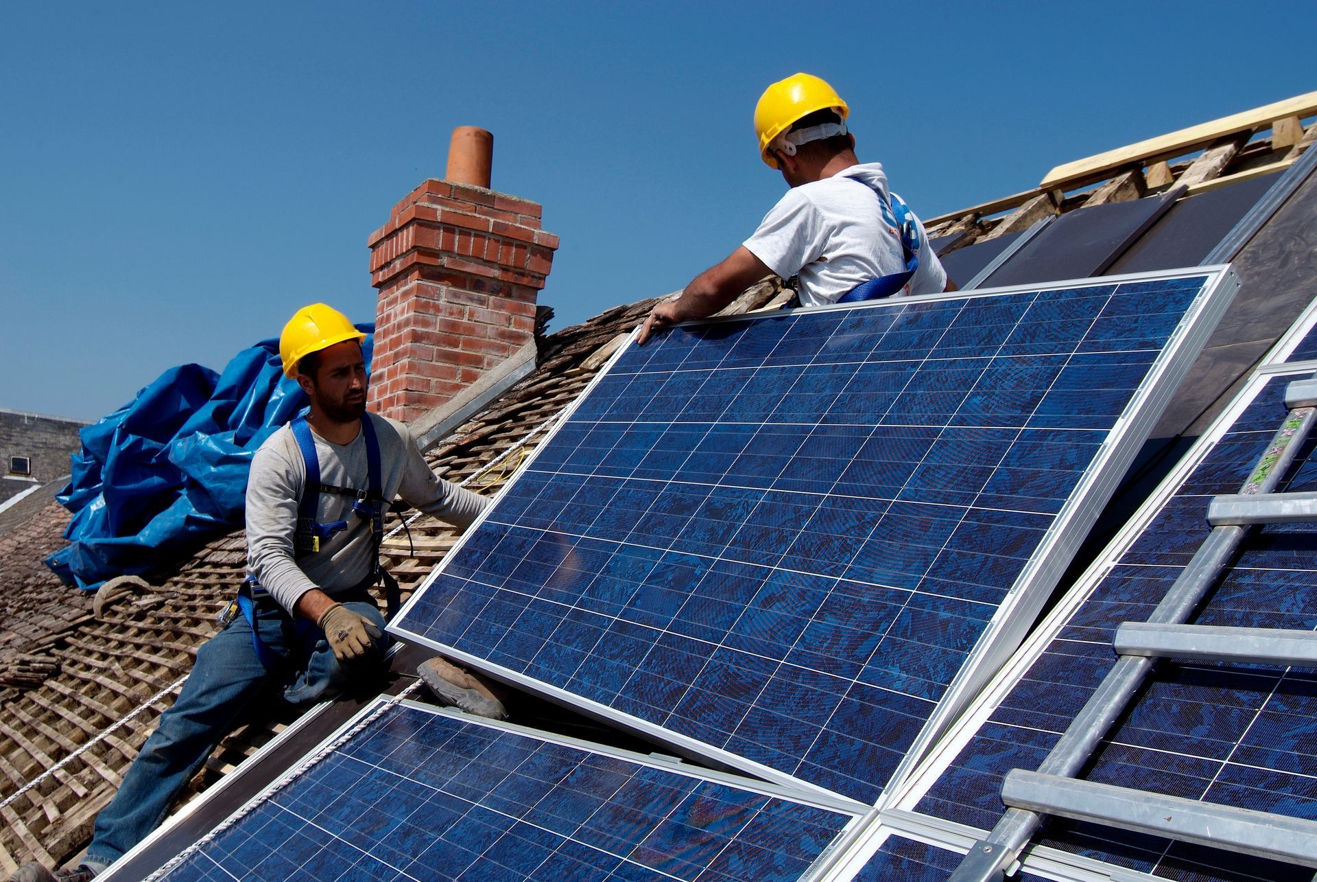 Pose de panneaux Photovoltaïques sur toit par deux ouvriers