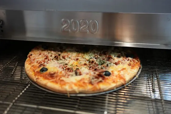 Cuisson de pizza sur une grille à l'intérieur d'un four en acier inoxydable