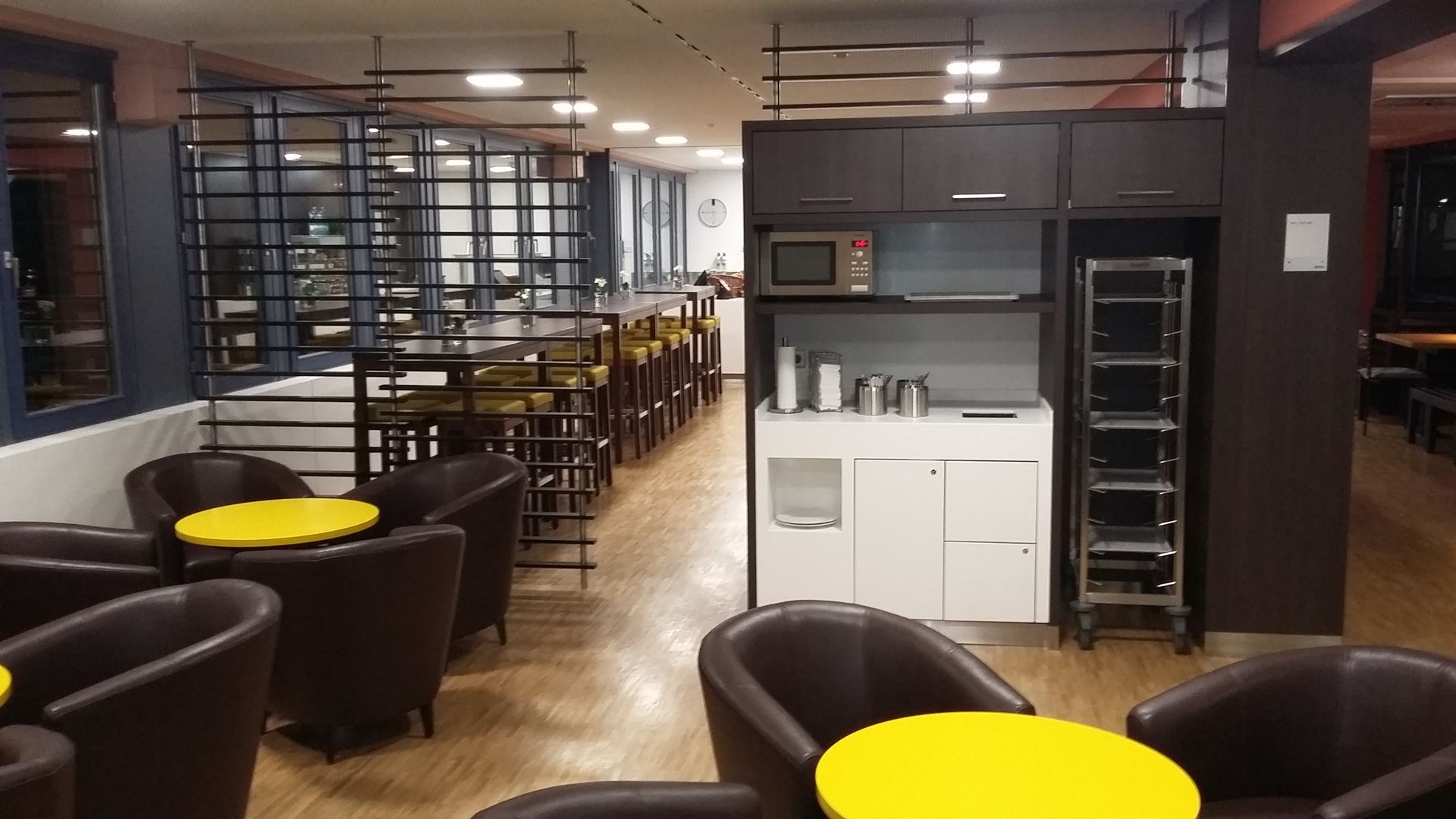 Ein Restaurant mit Tischen und Stühlen und einer Küche.