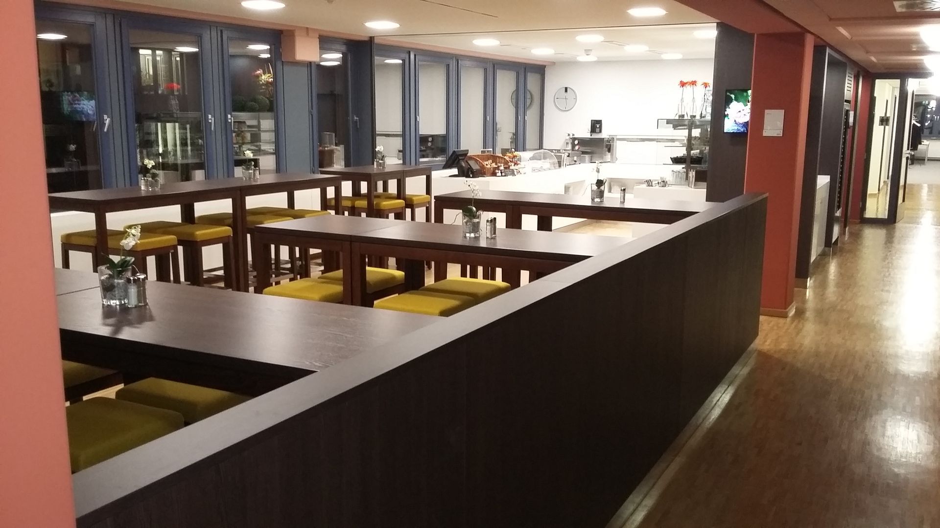 Ein langer Flur mit Tischen und Stühlen