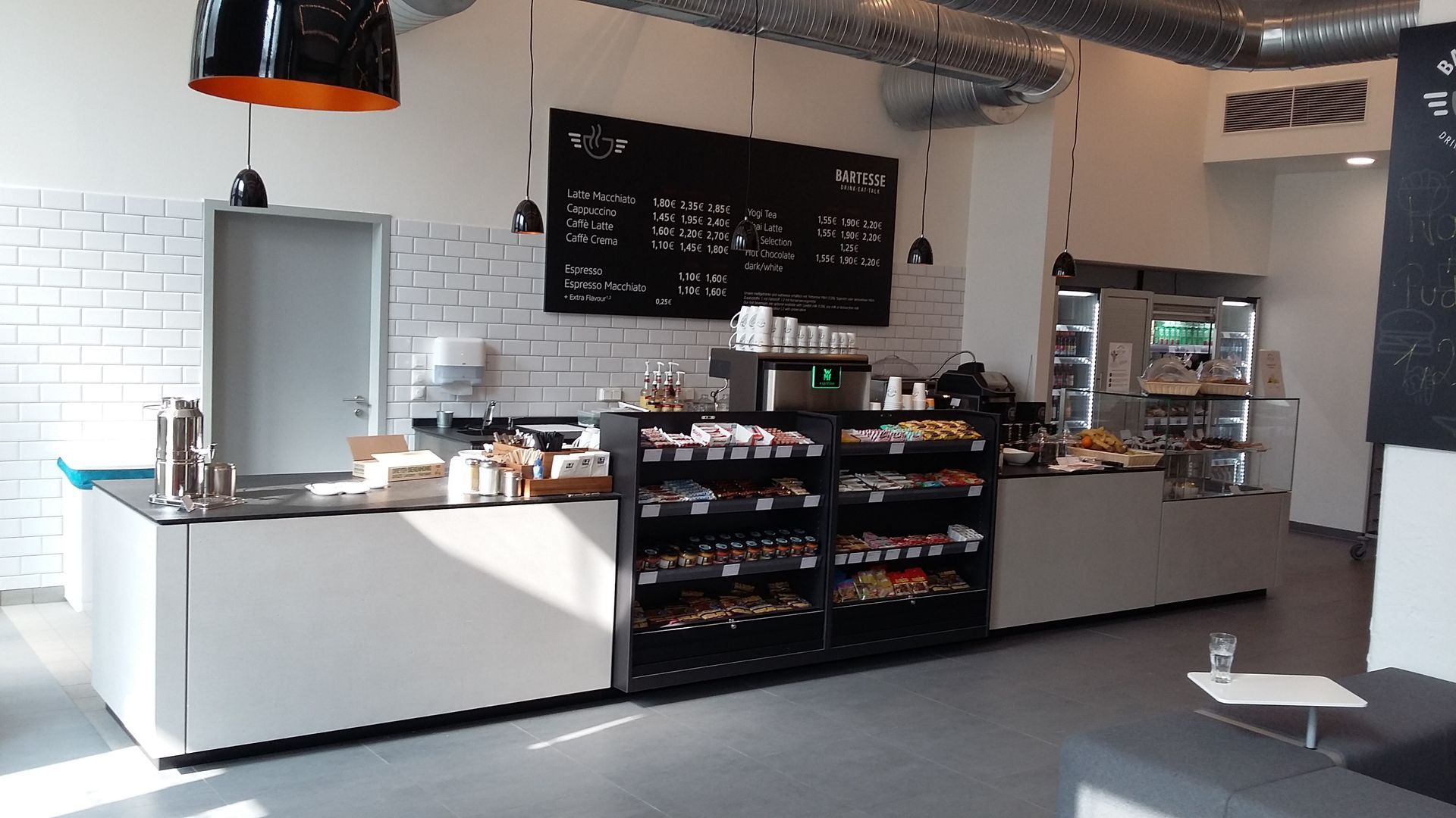 Ein Restaurant mit einer langen Theke und einer Kreidetafel an der Wand