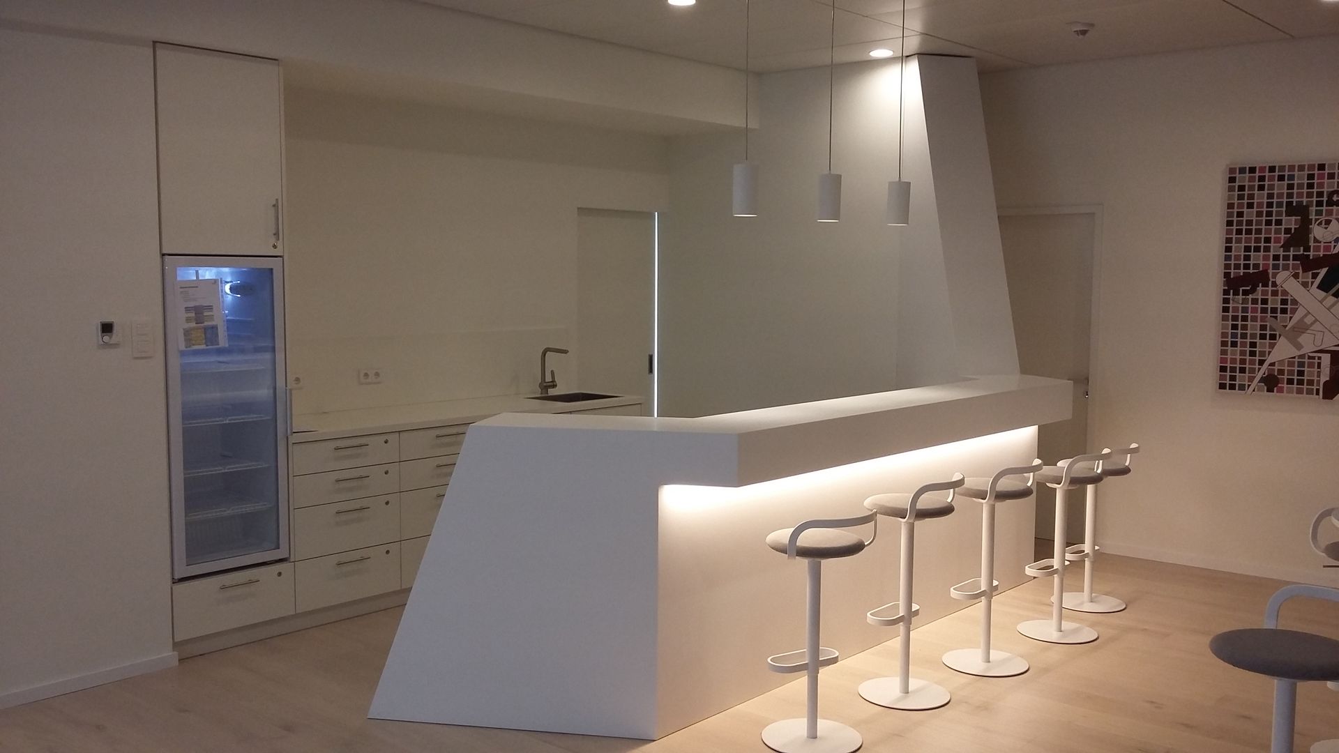 Eine Küche mit Bar und Hockern und einem Kühlschrank