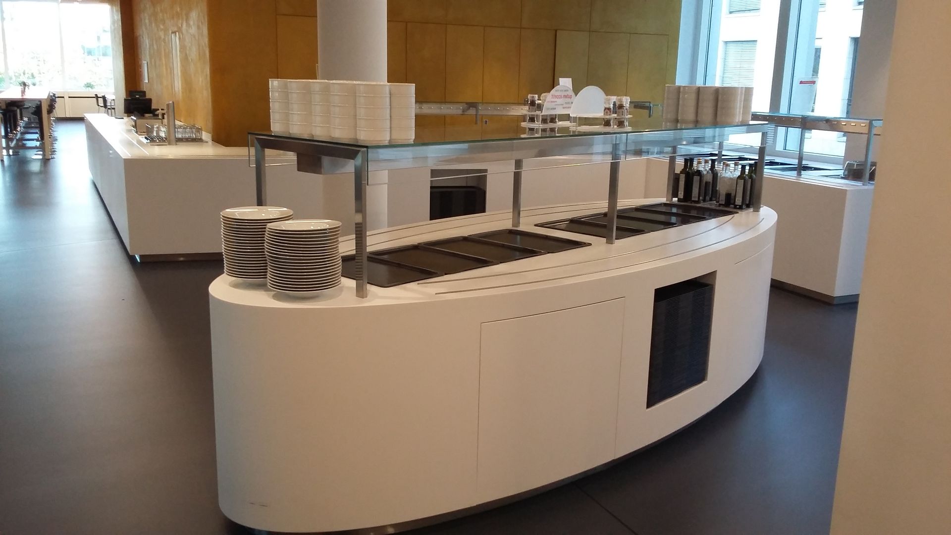 Eine lange weiße Theke mit Tellern darauf in einem Restaurant.