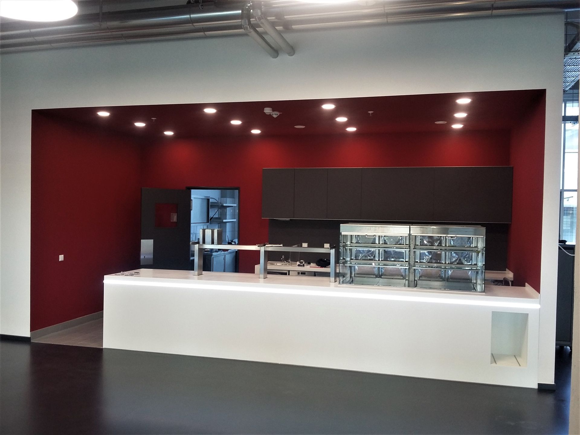 Eine Küche mit roten Wänden und weißen Arbeitsplatten