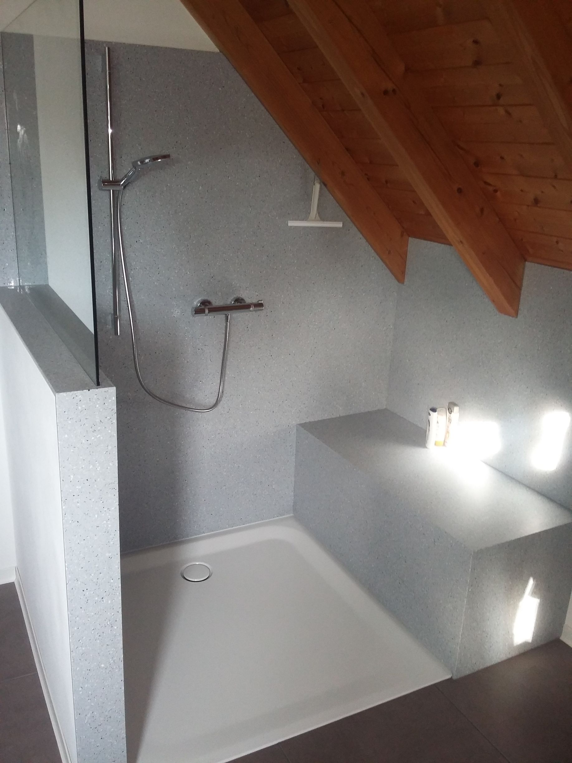 Ein Badezimmer mit Dusche und Holzdecke