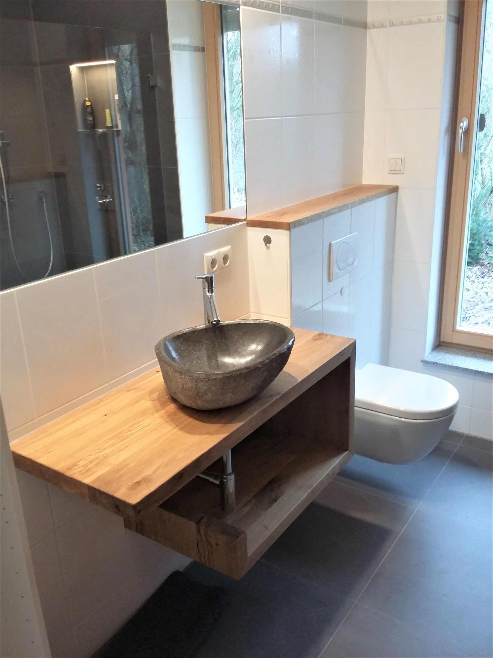 Ein Badezimmer mit Waschbecken, Toilette und Spiegel