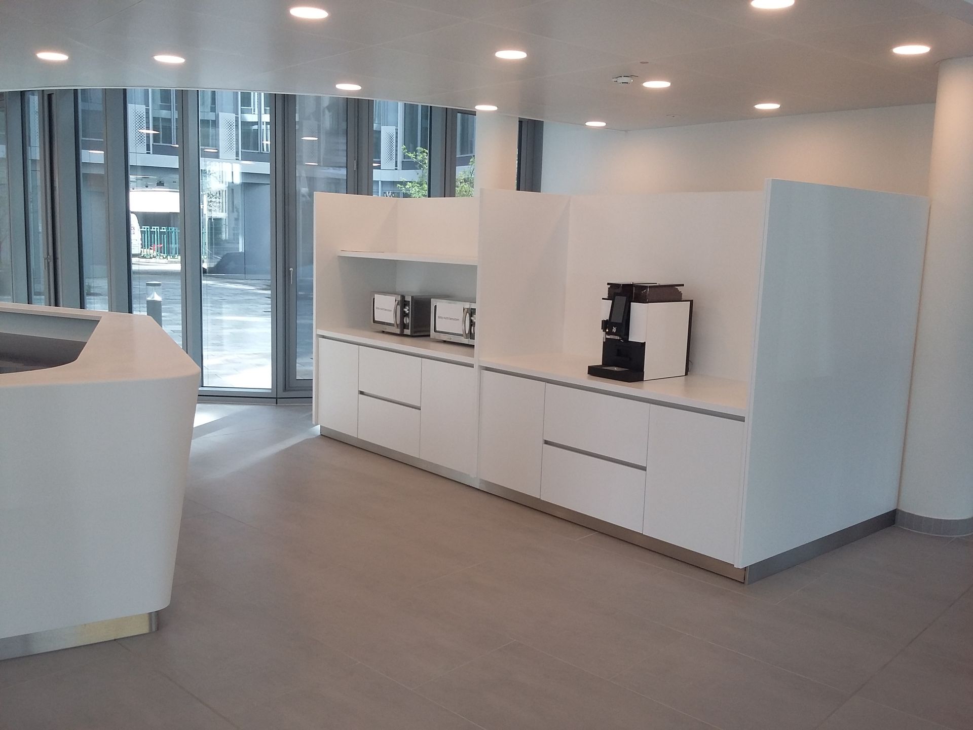 Eine Küche mit weißen Schränken und einer Kaffeemaschine